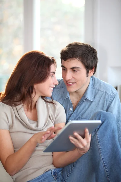 Młoda para przy użyciu elektronicznego komputera typu tablet w domu — Zdjęcie stockowe