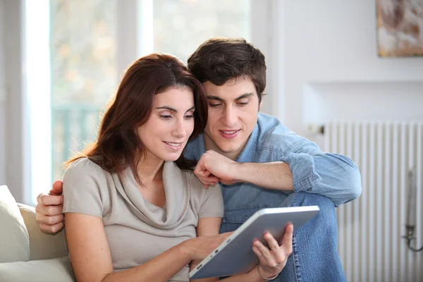 Mladý pár, pomocí elektronické počítače tablet doma — Stock fotografie