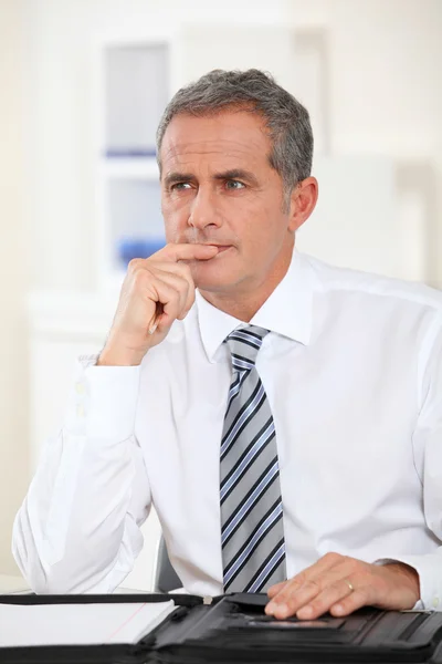 Porträtt av affärsman som sitter vid sitt skrivbord — Stockfoto