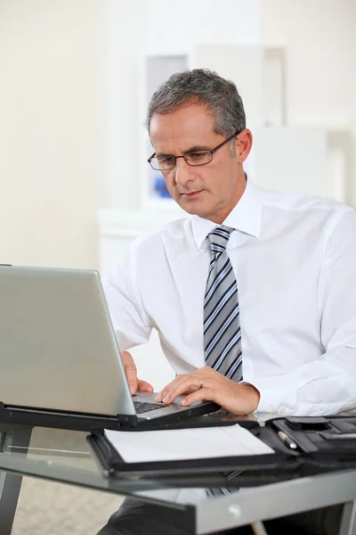 Portret van zakenman die op laptopcomputer werkt — Stockfoto