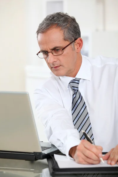 Portrait of businessman working on laptop computer — Stock Photo, Image