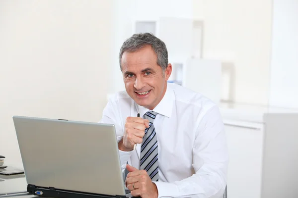 Portret van lachende zakenman achter computer — Stockfoto