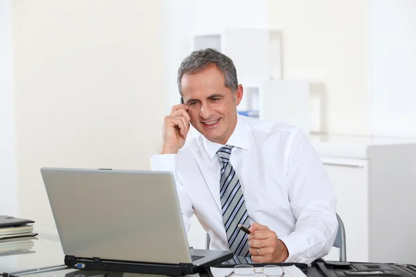 Porträtt av leende affärsman framför dator — Stockfoto