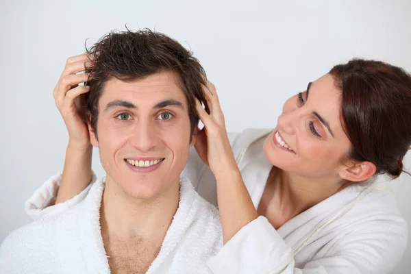 Jovem mulher colocando as mãos no cabelo do namorado — Fotografia de Stock
