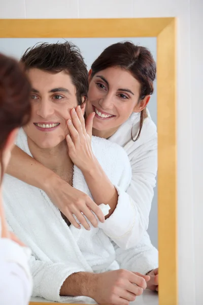 Kadın erkek arkadaşının yanağından nemlendirici uygulayarak — Stok fotoğraf