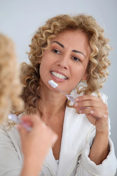 Πορτραίτο γυναίκας, βουρτσίζετε τα δόντια της μπροστά από τον καθρέφτη — Φωτογραφία Αρχείου
