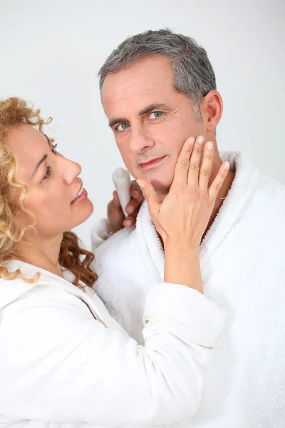 Donna che applica crema idratante sulla guancia del fidanzato — Foto Stock
