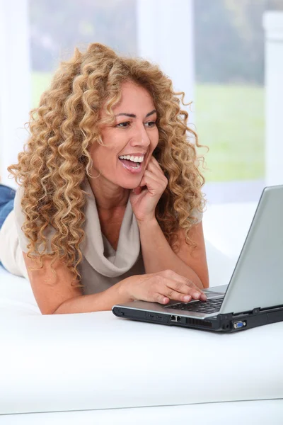 Mujer en casa usando ordenador portátil — Foto de Stock