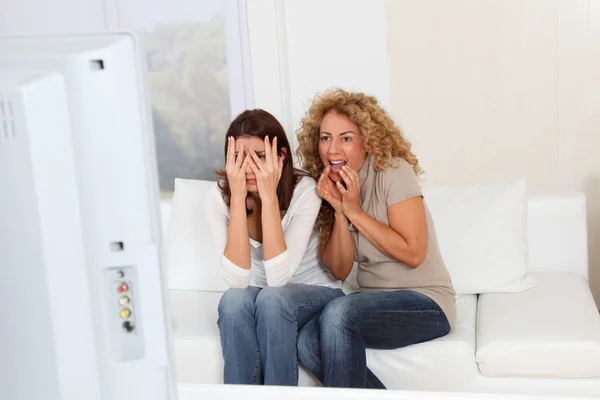Chicas amigas viendo una película de miedo en la televisión —  Fotos de Stock