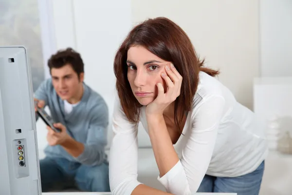 Jovem mulher farta de namorado jogando videogame — Fotografia de Stock