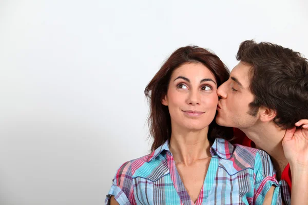 Jovem beijando namorada na bochecha — Fotografia de Stock