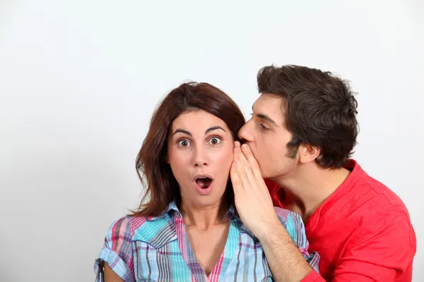Jeune homme chuchotant dans l'oreille de sa petite amie — Photo