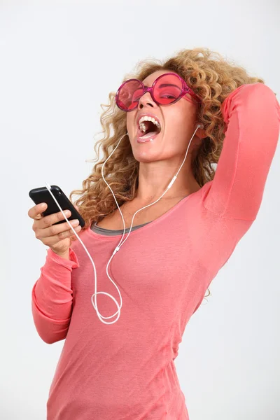 Portret van blonde vrouw luisteren naar muziekspeler — Stockfoto