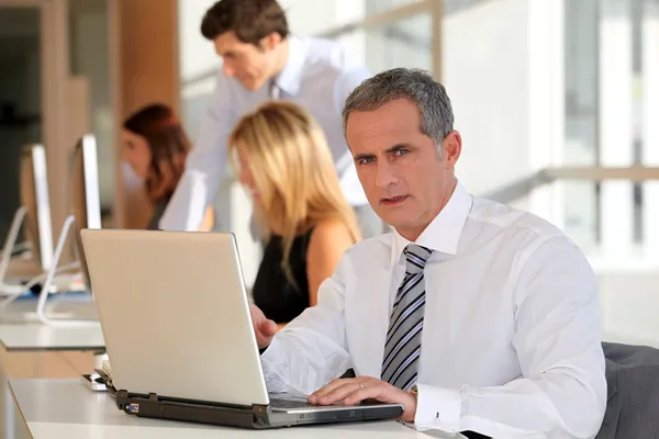 Volwassen zakenman die op laptopcomputer werkt — Stockfoto