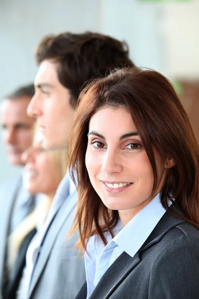 Lächelnde Geschäftsfrau inmitten einer Gruppe — Stockfoto