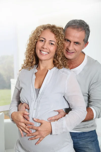 Parents with hands on pregnant woman's belly — Stock Photo, Image
