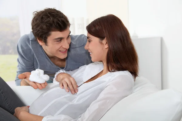 Mann gibt Neugeborenen Hausschuhe an zukünftige Mutter — Stockfoto