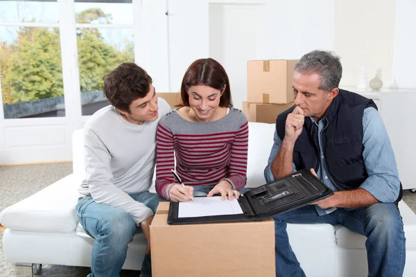 Ungt par underteckna kontrakt för att flytta hem — Stockfoto
