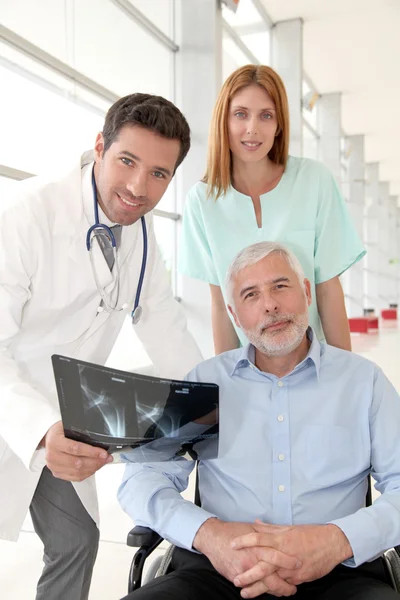 Medical team checking X-ray with patient — Stock Photo, Image