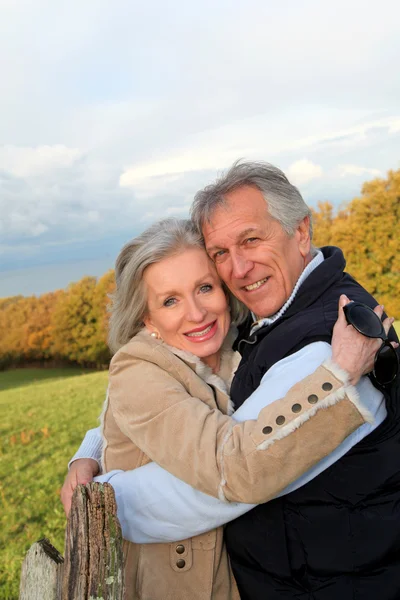 Happy senior couple embracing each other in countryside Stock Image