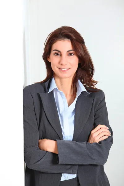 Businesswoman standing against white wall Stock Photo