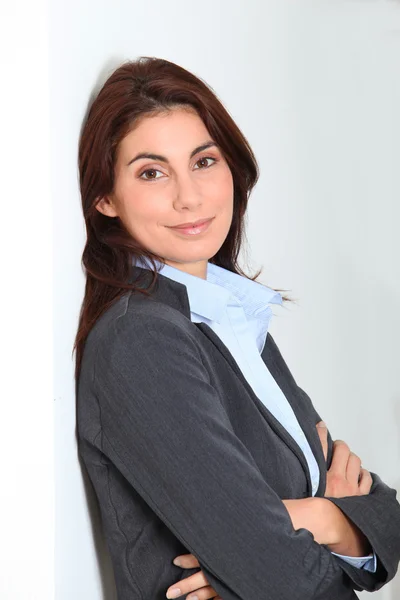 Businesswoman standing against white wall Stock Image