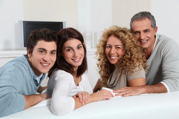 Group of friends sitting in sofa watching tv Royalty Free Stock Images