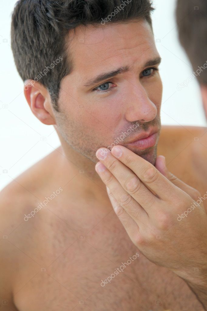 Portrait of attractive man looking at mirror