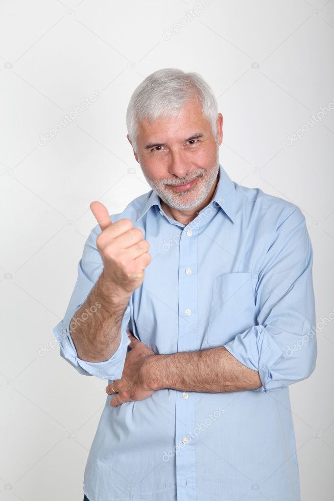 Portrait of smiling senior man wih thumb up