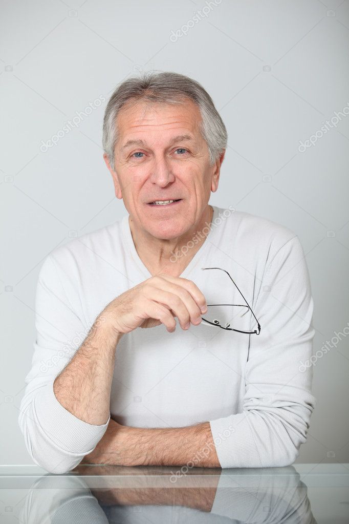 Closeup of senior man holding eyeglasses