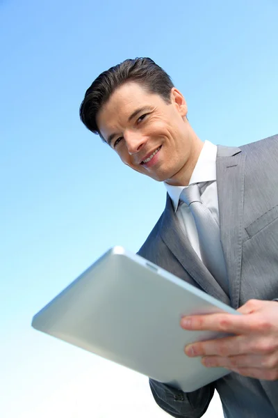 Porträt eines Geschäftsmannes, der an einem elektronischen Tablet arbeitet — Stockfoto