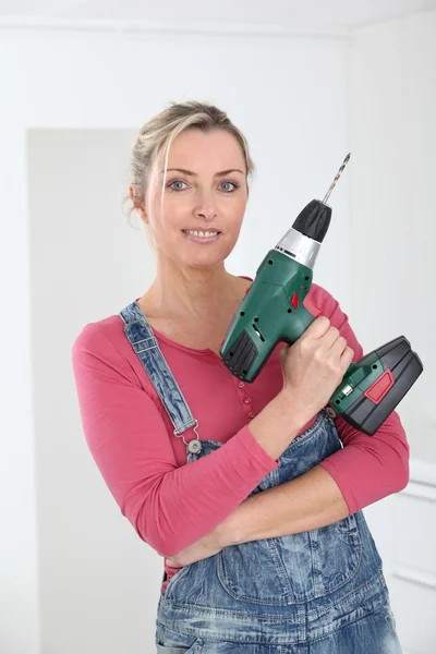Beautiful blond woman holding electric drill — Stock Photo, Image