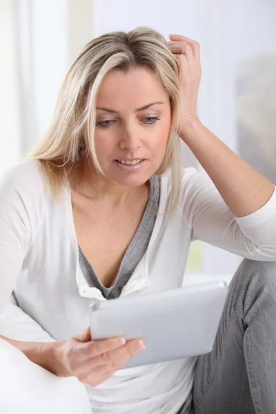 Mulher loira usando tablet eletrônico em casa — Fotografia de Stock