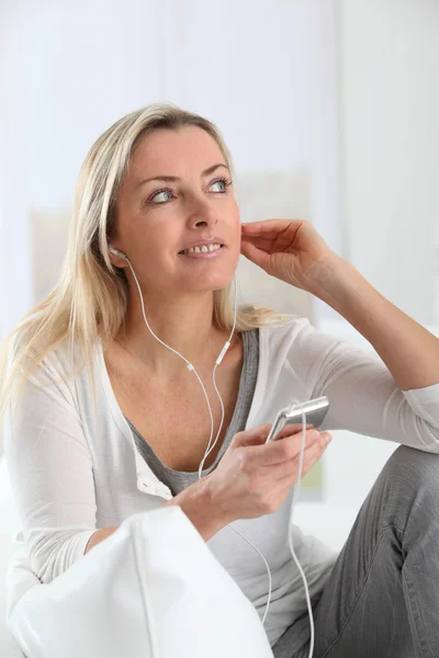 Mooie blonde vrouw luisteren naar muziek — Stockfoto
