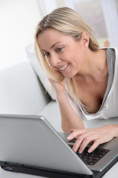 Adulto mulher loira conectado na internet em casa — Fotografia de Stock