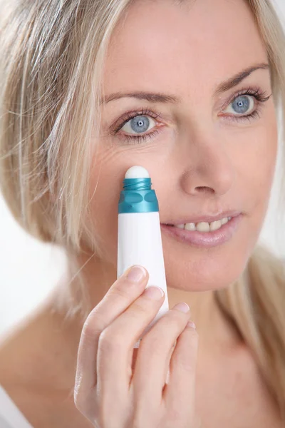 Blonde vrouw toepassing anti-veroudert serum op haar huid — Stockfoto