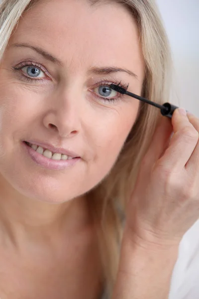 Vacker blond kvinna tillämpa makeup i ansiktet — Stockfoto