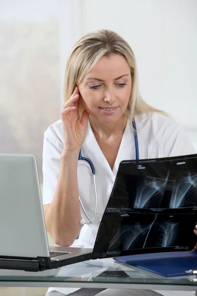 Vacker blond sjuksköterska tittar på röntgen — Stockfoto