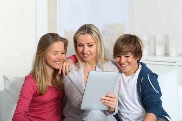 Familia divirtiéndose en casa usando tableta electrónica —  Fotos de Stock