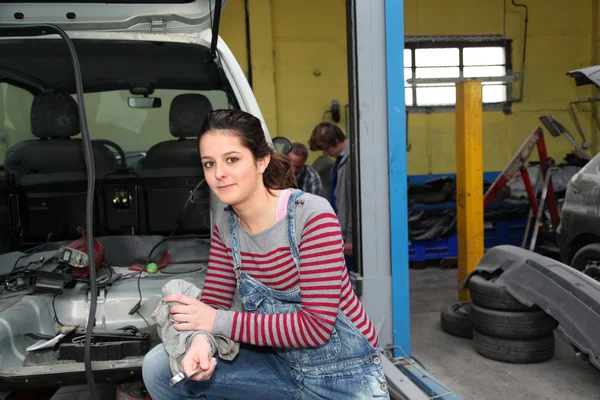 Tonårig flicka står vid fordonet i workshop — Stockfoto