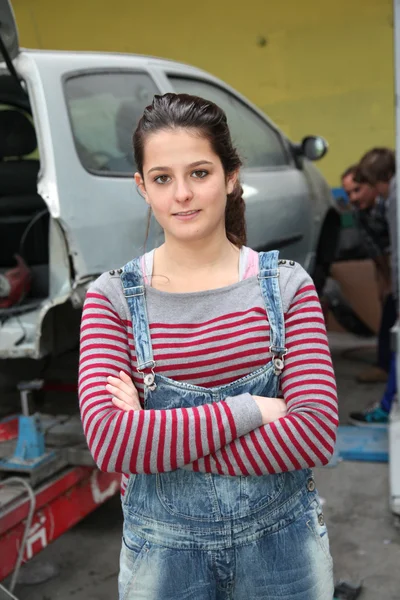 Ragazza adolescente in piedi accanto al veicolo in officina — Foto Stock