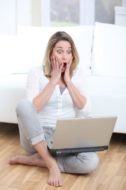 dizüstü bilgisayar önünde şaşırmış kadın