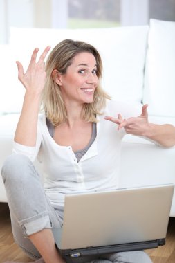 mutlu bir kadın evde dizüstü bilgisayar kullanma