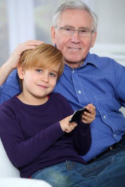 yaşlı adam telefonda video oyunu oynarken küçük çocuk ile