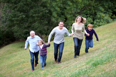 Family having fun running in park clipart