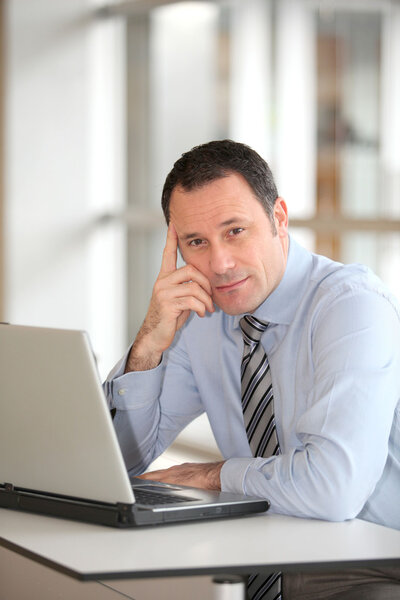 Портрет бизнесмена перед ноутбуком
