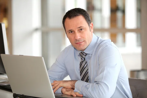 Portrait of businessman in front of laptop computer — Stock Photo, Image