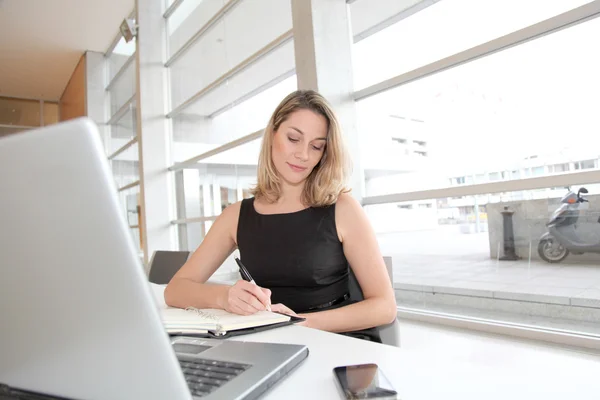 Businesswoman writing appointment on agenda — Stock Photo, Image
