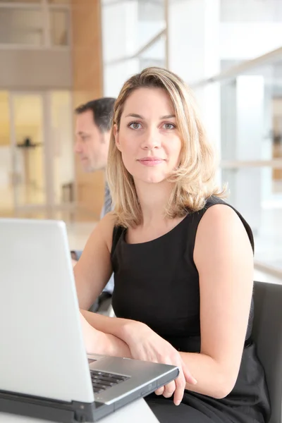 Бізнес-леді сидить в офісі перед ноутбуком — стокове фото