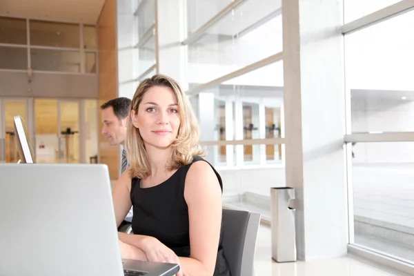 Geschäftsfrau sitzt im Büro vor Laptop — Stockfoto